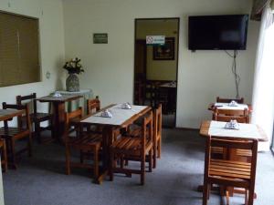奇廉Hotel de la Avenida的用餐室配有桌椅和平面电视。