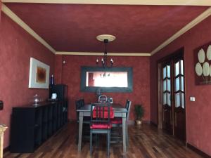 福恩吉罗拉Los Girasoles的一间拥有红色墙壁和桌椅的用餐室