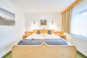 洛伊塔施豪斯索恩维戈酒店的一间卧室设有一张大型木床和一个窗户。