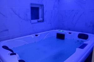 AndevilleSpa de la Nacre, L'étape Repos的浴室配有蓝色灯光的大浴缸