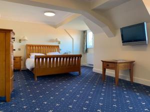 威尔汉姆斯普林菲尔德乡村酒店及休闲俱乐部及Spa的卧室配有一张床,墙上配有电视。