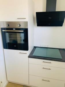 杜塞尔多夫Wohnung Skandi-Home ruhige Lage NEU - Düsseldorf Nord的厨房配有白色橱柜和黑微波炉