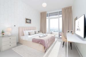 迪拜Ultimate Stay / 3 Beds / Gorgeous Frame and Park View / 250m from Metro / 1 Stop from World Trade Center的白色卧室设有床、书桌和窗户