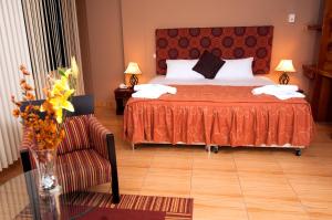 马尔多纳多港Hotel Puerto Amazonico的一间卧室配有一张床、一把椅子和一张桌子