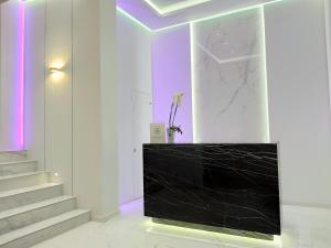 波利克罗诺Akrogiali Exclusive Hotel (Adults Only)的一间设有黑色柜台和楼梯的房间