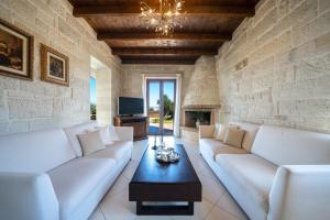 干尼亚FOS residence - ΦΩΣ ,luxury villa的客厅配有白色的沙发和石墙