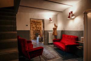 阿巴迪亚圣萨尔瓦托雷B&B La Castellina的客厅配有红色椅子和镜子
