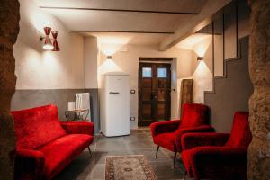 阿巴迪亚圣萨尔瓦托雷B&B La Castellina的一间设有红色椅子和白色冰箱的房间