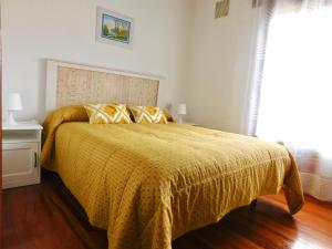 FuenmayorLa Pilarcita Centro的一间卧室配有一张黄色棉被的床