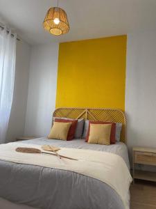 贝尔福Bel'flora的一间卧室设有一张黄色墙壁的大床
