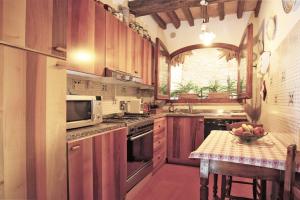 波吉奥的圣多纳托Apartment in B&B Del Giglio的厨房配有木制橱柜和1张带水果碗的桌子