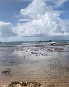 普拉亚多Praia do Forte Kauai Bahia的一片云天和海洋的海滩
