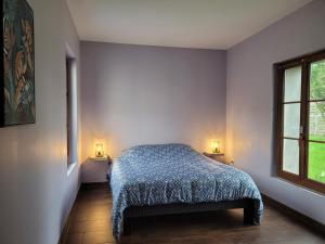 BranslesUn nid pour la nuit的卧室配有一张床,墙上有两盏灯