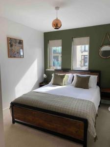 纽波特Luxury 2 Bedroom waterfront apartment with balcony的一间卧室设有一张带绿色墙壁的大床