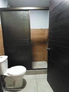 阿拉胡埃拉Hogar tico-estadounidense cerca de aeropuerto的浴室设有卫生间和门淋浴。