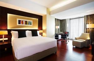 达卡孟加拉达卡阿玛瑞酒店的一间卧室配有一张床、一张桌子和一把椅子