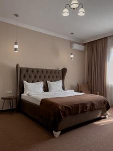 阿拉木图Keremet Hotel的一间卧室设有一张大床和一个窗户。