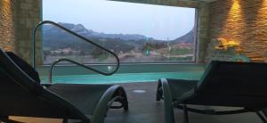 BotHotel & Spa Can Josep的带窗户的客房内的带两把椅子的游泳池