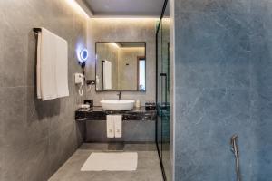Thinadhoo马尔代夫羽毛旅馆的一间带水槽、镜子和淋浴的浴室