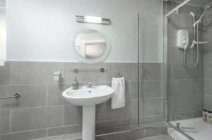 莫珀斯Newminster Cottage的一间带水槽、镜子和淋浴的浴室