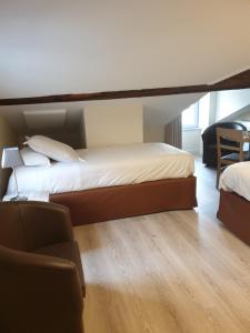 昂瑟尼L'Hotellerie de la Toile à Beurre的客房设有两张床、椅子和沙发。