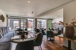 代尔夫特皇家桥酒店的餐厅设有桌椅和沙发。