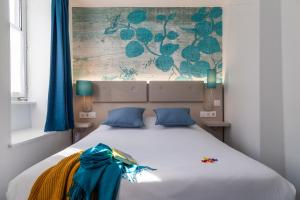 斯特拉斯堡维多利亚酒店的卧室配有带蓝色枕头的大型白色床