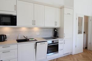 德累斯顿Zu Besuch im Palast - Perfekte Lage的白色的厨房配有白色橱柜和水槽