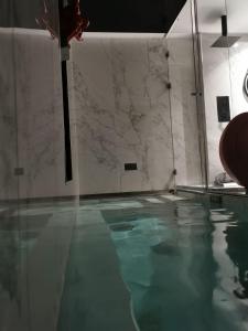 BabilafuenteLexury Suite Acqua的一个带大理石墙的房间的游泳池