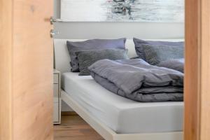 加尔米施-帕滕基兴Apartment BergArt的床上铺有灰色枕头的床