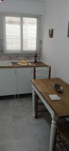 卡尔佩Apartamento junto al Peñon de Ifach con parking的厨房配有白色橱柜和木桌