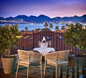 戛纳Hotel Le Suquet Cannes的海景阳台上的桌椅