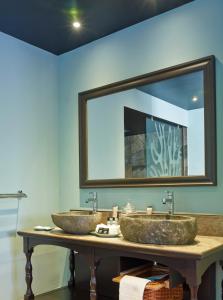 圣皮埃尔迪莱尔别墅酒店及Spa的浴室内配有镜子,桌子上设有两个水槽