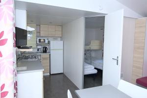 萨瑟托勒玛肯杜Camping L'oiseau Blanc的带白色家电的厨房和1间带床的房间