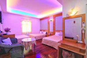 鹅銮鼻龍坑民宿的紫色客房配有两张床和一台电视机