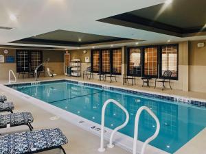 斯特布里奇Comfort Inn & Suites Sturbridge-Brimfield的一个带桌椅的大型游泳池
