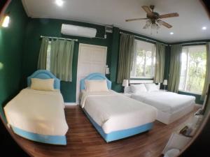 Baan Wang Mi考亚自然度假村的配有两张床的客房,设有绿色的墙壁和镜子