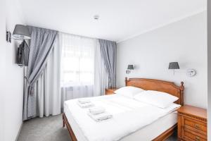凯尔采波德斯洛塔罗萨酒店的一间卧室配有一张带白色床单的床和一扇窗户。
