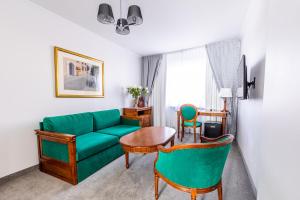 凯尔采波德斯洛塔罗萨酒店的客厅配有绿色沙发和椅子