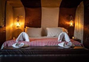 姆哈米德Bivouac de luxe Mhamid的一间卧室配有一张大床和拖鞋