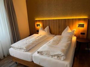 汉诺威艾玛迪斯餐厅酒店的一间卧室配有两张带白色毯子和枕头的床