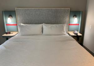 塞勒姆avid hotels - Salem, an IHG Hotel的一张带白色枕头的大床和2个床头柜