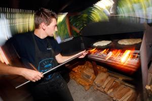 BassembergMobil Home XXL 4 chambres - Camping Le Giessen的一个人在烧烤架上做饭