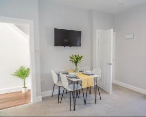艾尔The Mila - Ayr Racecourse - Coorie Doon Apartments的白色的用餐室配有桌椅