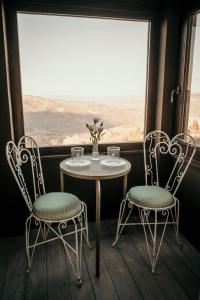 阿巴迪亚圣萨尔瓦托雷B&B La Castellina的窗户间里的一张桌子和两把椅子