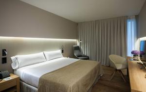 Vilassar de Dalt苏丽埃莫绅酒店的酒店客房设有一张大床和一张书桌。
