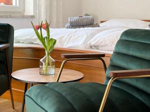 沃尔特湖畔佩莎赫小猫宾馆的客厅配有床和花瓶,摆放在桌子上