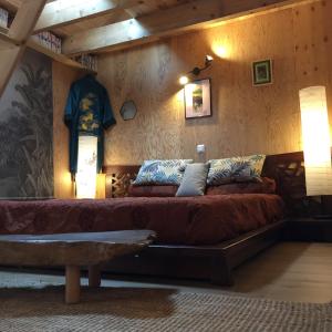 贝隆河畔日克Les 3 Koïs的木墙客房内的一张大床