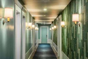 巴黎Holiday Inn Paris - Gare de Lyon Bastille, an IHG Hotel的走廊上设有绿色的墙壁和灯光,走廊上设有走廊