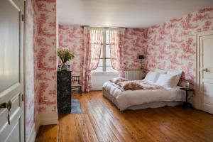 阿姆博斯MAISON HULOTTE的卧室配有粉红色花卉壁纸和1张床